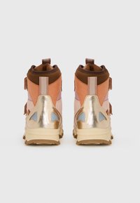 Hochschuh-Sneaker, die eine Mischung aus pinken, braunen und goldenen Materialien aufweisen; metallische Akzente, strukturierten Stoff und eine robuste Gummisohle.