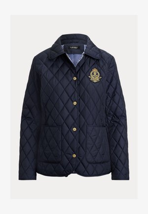 Tamsiai mėlyna dygsniuota striukė su rombų raštu, auksiniais mygtukais, dviem priekinėmis kišenėmis ir dryžuotu vidiniu pamušalu. Papuošta išsiuvinėtu emblematu.