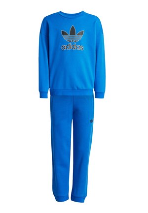 Niebieski zestaw dresowy Adidas składający się z bluzy z okrągłym dekoltem z czarnym logo oraz dopasowanych spodni ze ściągaczem i bocznymi kieszeniami.