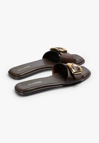 Brune læderslide-sandaler med en bred strop og detalje med guld-tone spænde, flad sål og prægede logo på indersålen.