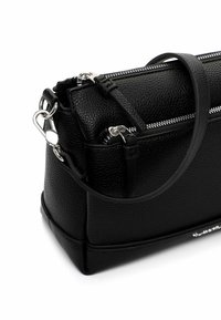 Czarna torebka z teksturowanej skóry z srebrnymi zamkami błyskawicznymi, odpinanym paskiem i usztywnionym kształtem. Posiada solidną podstawę i polerowane elementy ozdobne.