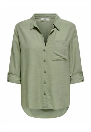 Camisa de botones verde claro con cuello, un bolsillo en el pecho y mangas enrollables. Hecha de un tejido suave y texturizado con un dobladillo curvado.