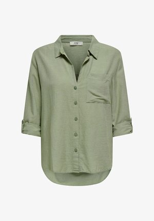 Camisa de botones verde claro con cuello, un bolsillo en el pecho y mangas enrollables. Hecha de un tejido suave y texturizado con un dobladillo curvado.