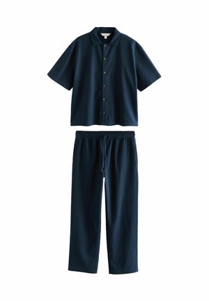 Cămașă scurtă cu mânecă din navy blue, cu deschidere cu nasturi și pantaloni asortați cu talie elastică, cu un material texturat și o croială lejeră.