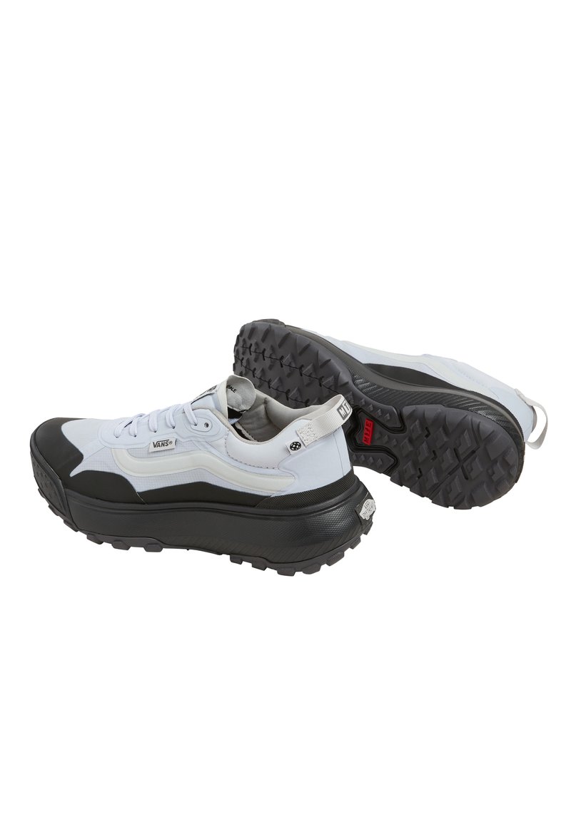 Zapatillas blancas y negras con una suela gruesa y texturizada; diseño estrecho; parte superior de tejido texturizado; cordones y lengüeta; acentos de marca en el costado.