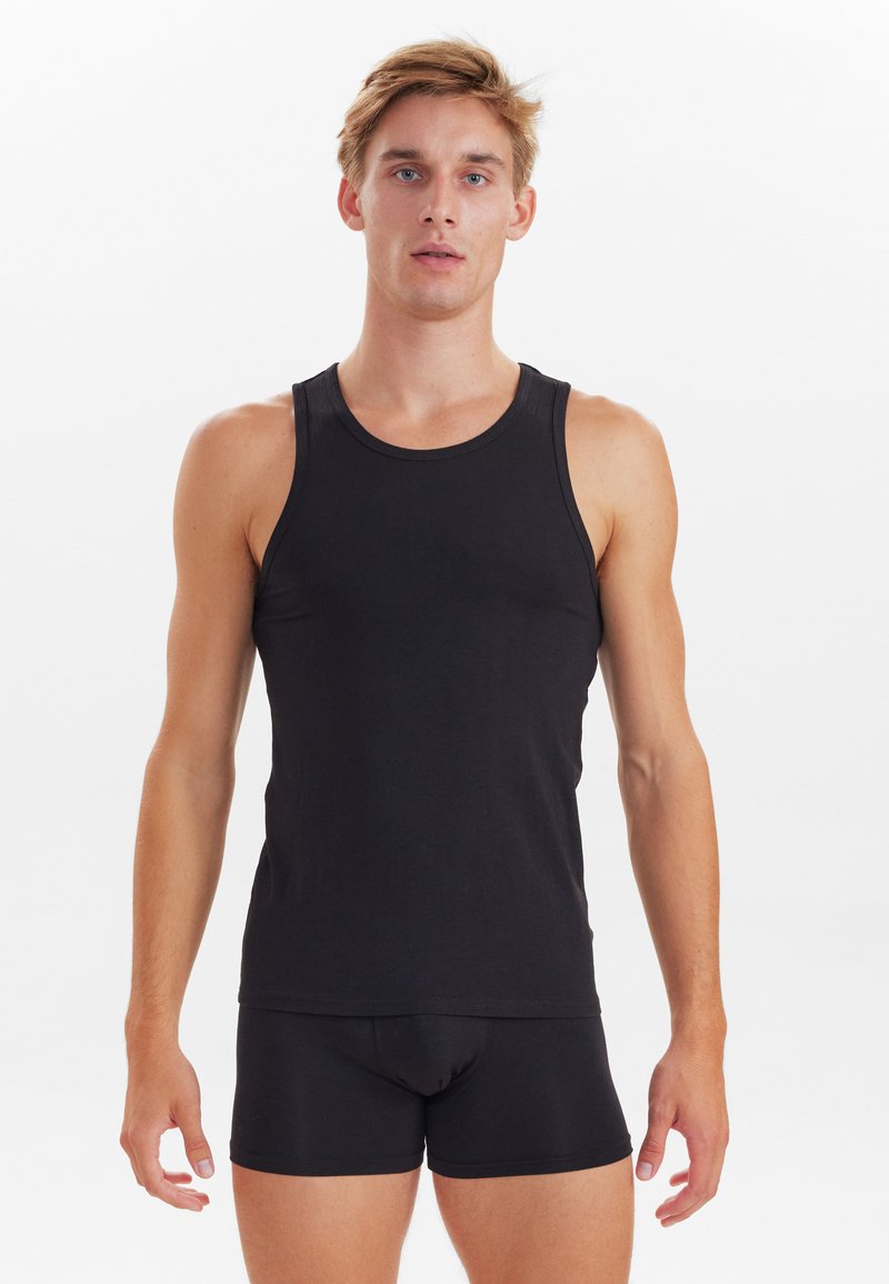 Schwarzes Tanktop aus weichem Stoff, mit Rundhalsausschnitt, ärmellosem Design und kombiniert mit passenden schwarzen Boxershorts.