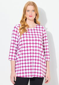 Camicetta rosa e bianca a pois con maniche a tre quarti, scollatura rotonda e vestibilità comoda. Tessuto liscio e leggero.