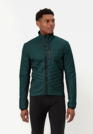 Dunkelgrüne gepolsterte Jacke mit einem Stehkragen, schwarzen Seitenpaneelen und einem durchgehenden Frontreißverschluss. Verfügt über eine gesteppten Struktur im Brustbereich.