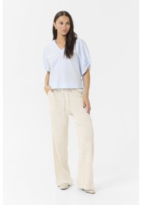 Light blue striped short-sleeve top paired with loose-fitting cream-colored trousers. Textured fabric, relaxed design, and drawstring waist.