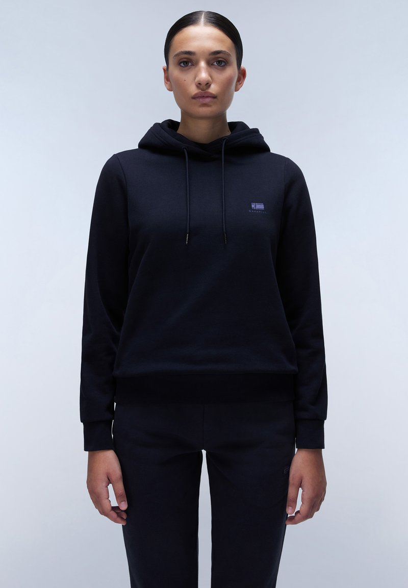 Zwarte hoodie van zachte stof met een trekkoordkap, geribbelde manchetten en een klein logo op de borst. Gecombineerd met bijpassende zwarte broek.