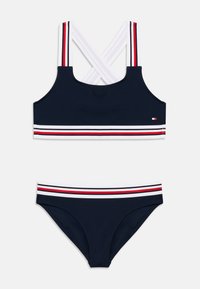 Σετ μπικίνι σε ναυτικό μπλε χρώμα με τοπ διασταυρούμενης πλάτης που έχει λευκές και κόκκινες ρίγες και κάτω μέρος που ταιριάζει με ριγωτή μέση. Κατασκευασμένο από ελαστικό υλικό για κολύμπι.