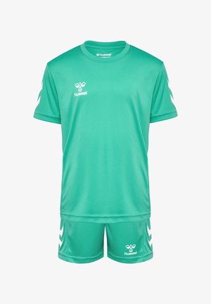 Groen sportoutfit gemaakt van lichtgewicht stof. Het shirt met korte mouwen en de shorts hebben een wit logo en chevron-accenten op de mouwen en aan de zijkant.
