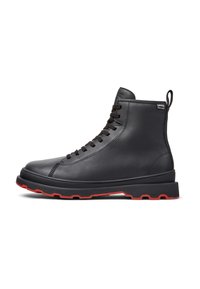 Black leather high-top boot with red sole, featuring laces and a pull tab at the back, showcased against a white background.