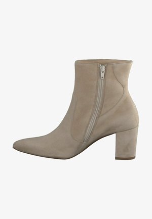 Beige suede enkellaars met een spitse neus, zijrits en een chunky hak. Soepele textuur met een minimalistisch ontwerp en stiksels als accent.