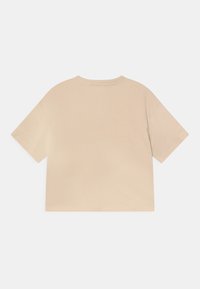 Camiseta corta de manga corta beige con escote redondo, presentada plana desde la parte trasera sobre un fondo blanco.