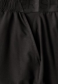 Shorts de sport noirs en tissu lisse, dotés d'une taille élastique avec des lettres en relief et de coutures doubles pour plus de durabilité.