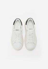 Vita sneakers med en texturerad sula, som har en slät ovandel, svarta hälaccenter och snörning. "DKNY"-logotyp på plösen.