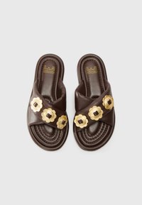 Brown slide sandals made of leather with a textured strap featuring gold flower-like accents and intricate stitching on the sole.