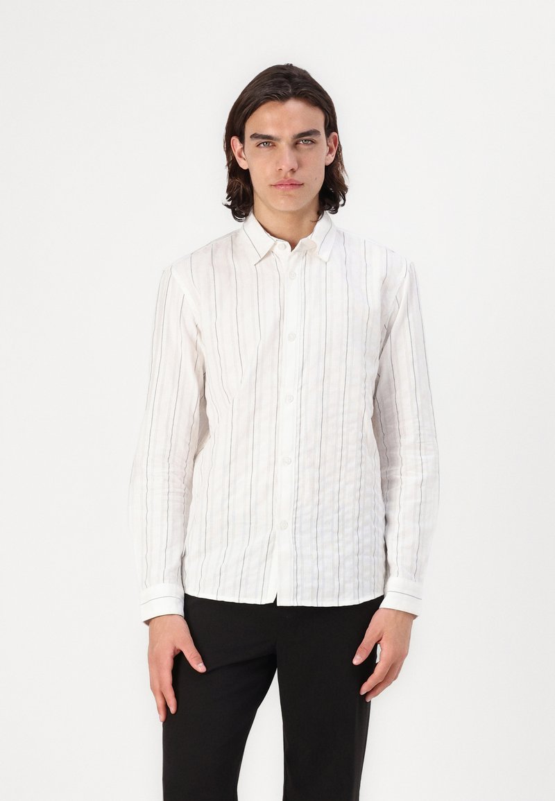 Witte langemouwige button-down shirt met verticale lichtgrijze en marineblauwe strepen. Voorzien van een klassieke kraag en verstelbare manchetten. Gladde textuur.