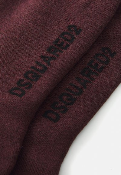 Bordó zoknik puha anyagból, fekete "DSQUARED2" logóval, mely jól láthatóan van nyomtatva az oldalon. Szabványos zokni forma és textúra.