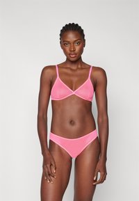 Set di reggiseno e slip rosa realizzato in tessuto morbido, dotato di spalline regolabili, design a coppa triangolare e vita elasticizzata.