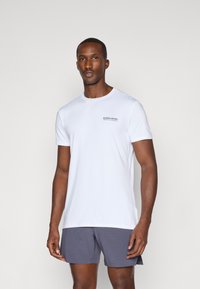 Λευκό κοντομάνικο μπλουζάκι από ελαφρύ ύφασμα, με στρογγυλή λαιμόκοψη και μικρό τυπωμένο λογότυπο στο αριστερό στήθος.