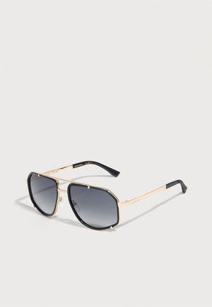 Rectangular aviator sunglasses with gold metal frame, black edges, and dark gradient lenses resting on a light surface.