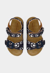 Μαύρα σανδάλια με στάμπα ποδοσφαίρου, διπλά λουράκια με αγκράφες και υφασμένο καφέ πέλμα. Ορατή ετικέτα μάρκας εσωτερικά.