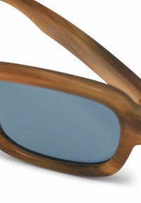 Sunglasses with brown tortoiseshell acetate frame and blue tinted lenses. Includes engraved details on the temple. Cat. 2 UV protection.