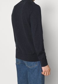 Dunkelblaues langärmliges Sweatshirt mit Rundhalsausschnitt, aus einem weichen Strickstoff gefertigt, mit gerippten Bündchen und einer leicht taillierten Passform.