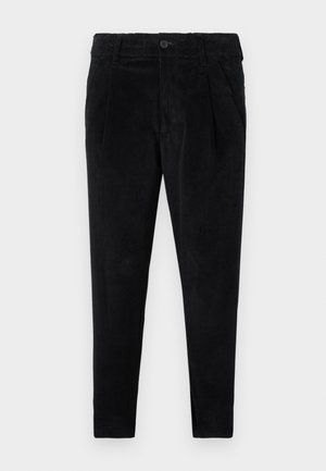 Mustard värvi puuvillased corduroy püksid slim fit lõikega, nööpkinni ja kahe ees olevate taskuga, millel on vertikaalne ribakujuline tekstuur.