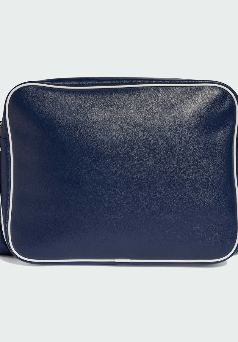 Marineblå lædertaske med glat tekstur, rektangulær form og hvid piping langs kanterne. Har en flad front og en aftagelig rem.
