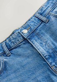 Jeansy dżinsowe w niebieskim kolorze, z lekkim wyblaknięciem, pięciokieszeniowym krojem oraz metalowym guzikiem w pasie i przeszyciami jako akcentami.