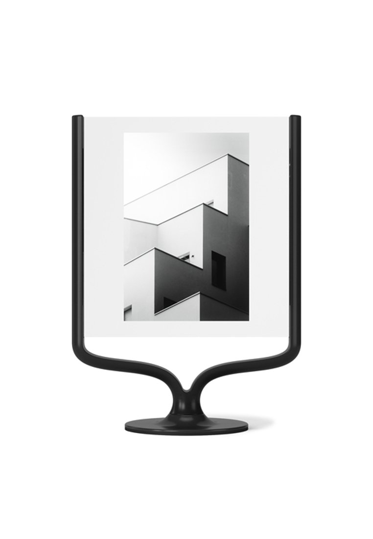 Czarna metalowa ramka ze szeregiem zakrzywionych podstaw, prezentująca czarno-białe zdjęcie geometrycznych kształtów budynków i cieni.