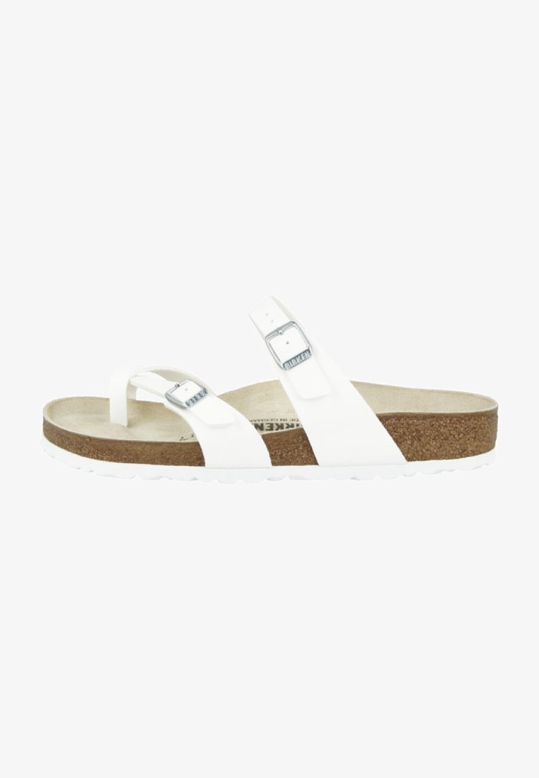 White sandal with two adjustable straps, silver buckles, and a cork footbed. Textured outsole for grip. Minimalistic design.