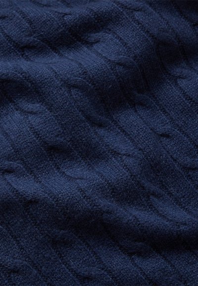 Navy blue cable-knit fabric with a soft, textured surface, featuring raised diamond patterns and a plush appearance. Suitable for garments.