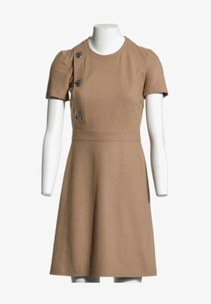 Robe courte beige à manches courtes, longueur genou, avec un col rond et trois boutons décoratifs sur le côté supérieur gauche, présentée sur un mannequin blanc.