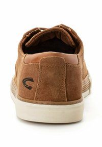Brune suede lav-top sneakers med et afrundet design, kontrasterende tan læderdetaljer og en hvid gummisål med struktureret greb.