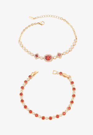 Dwie złote bransoletki z czerwonymi i przezroczystymi kamieniami szlachetnymi; jedna ma centralne owalne i kwadratowe czerwone kamienie, druga zawiera na przemian okrągłe czerwone i przezroczyste kamienie.