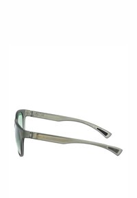 Gafas de sol con tinte verde, montura gris mate y brazos angulados. Presentan el logo "ROXY" en dorado en el costado. Diseño ligero.