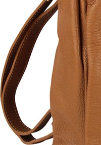 Close-up van een bruine leren tasriem met zichtbare stiksels op de buitenrand en zachte leerplooien.