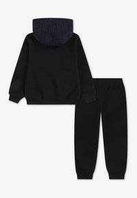 Zwarte sweatshirt met een patroon op de marineblauwe capuchon en bijpassende zwarte joggingsbroek. Voorzien van ribgebreide manchetten en een elastische tailleband voor comfort.