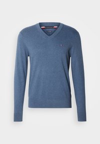 Pull bleu à col en V manches longues avec petit logo Tommy Hilfiger sur la poitrine et poignets et bas côtelés.