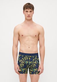 Navy boxer shorts featuring an avocado pattern in green and yellow. Soft fabric with a stretchy, branded waistband.