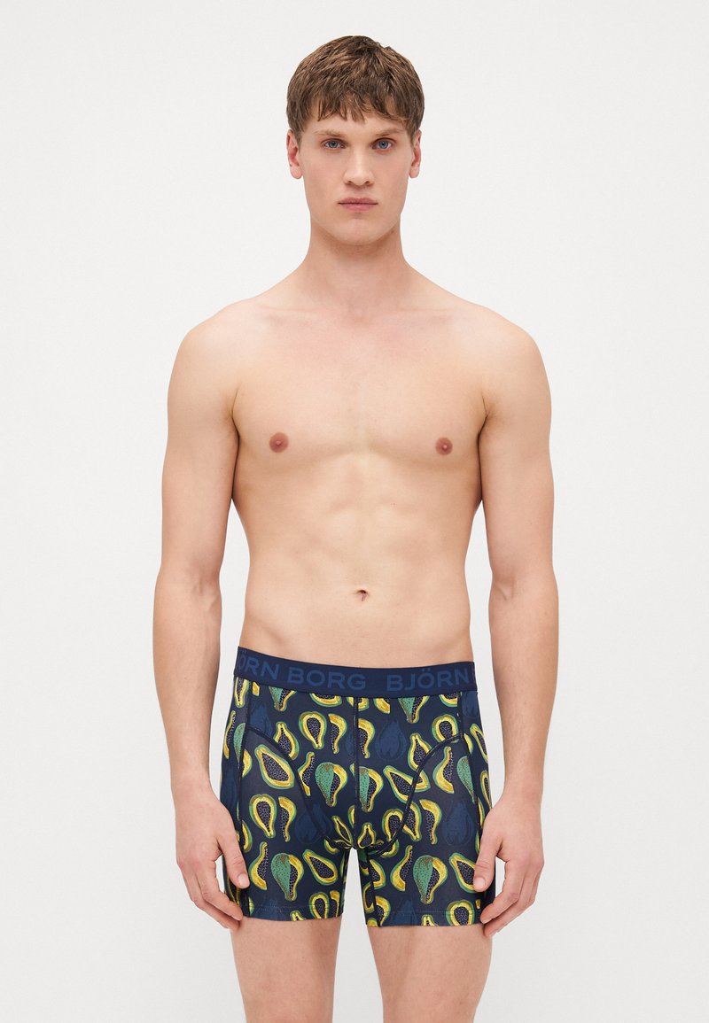 Navy boxer shorts featuring an avocado pattern in green and yellow. Soft fabric with a stretchy, branded waistband.