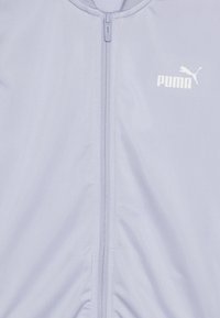 Svetlo vijolična zip-jakna iz gladkega materiala, s sprednjim zadrgo in majhnim belim logotipom Puma na levi strani.