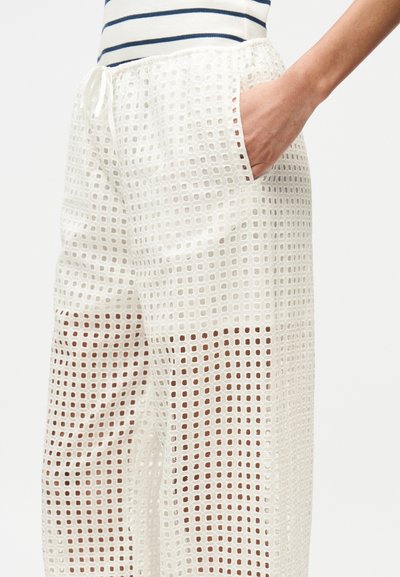 Λευκό, ελαφρύ παντελόνι με σχέδιο σε πλέγμα, διαθέτει ελαστική μέση και τσέπες στα πλάγια. Υφασμάτινο με υφή και αεριζόμενο.