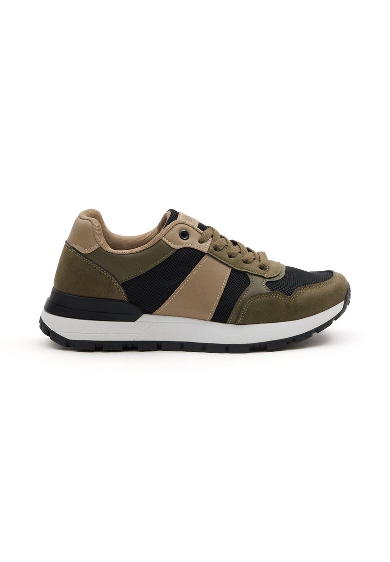 Zapatilla que presenta un upper de material mixto en ante verde oliva y malla negra, con un acento color beige. Suela acolchada y suela exterior de goma negra texturizada.