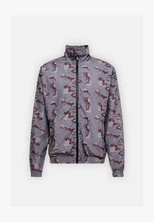 Ūdensizturīgs vēja pārvalks pelēkā krāsā ar jautru brūnu figūru rakstu un baltām akcentiem. Ar apkakli un elastīgām piedurknēm.