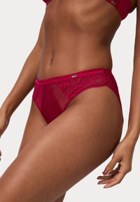 Roodachtige roze kanten bikini met doorzichtige meshpanelen, bloemenkantaccenten, een gladde tailleband en een klein metallic detail aan de voorkant.